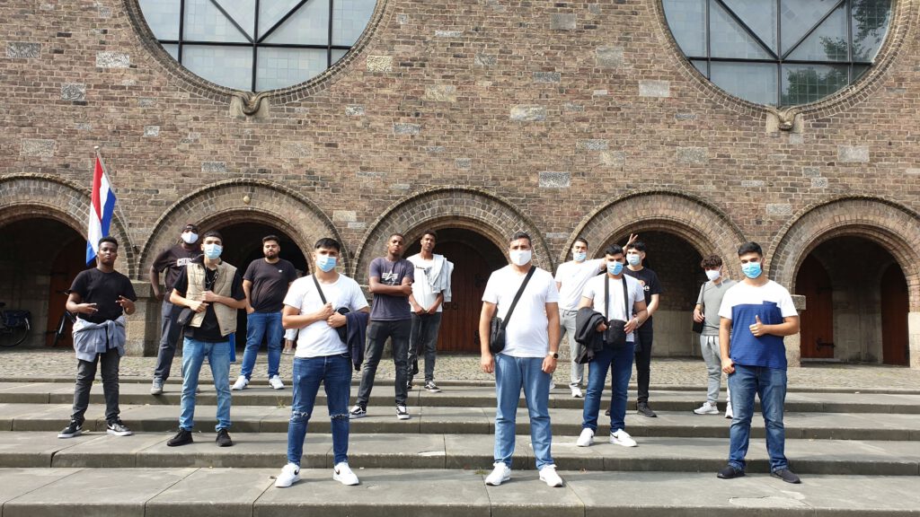 Die Jungengruppe des Jugendsalons des Begegnungszentrums Kinderhaus vor der Kirche am Alten Markt in Enschede.